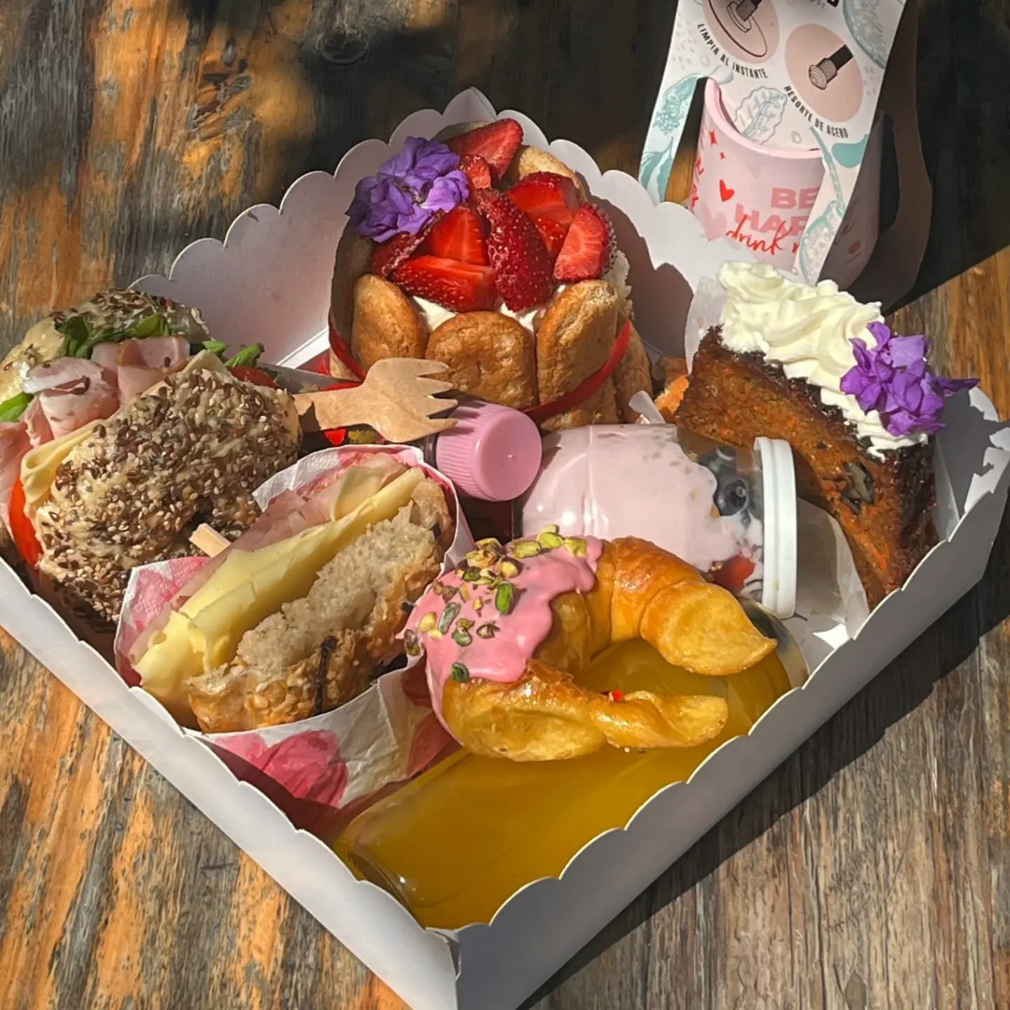 Open Antojitos breakfast box with croissants, pastry slices and sweet bites