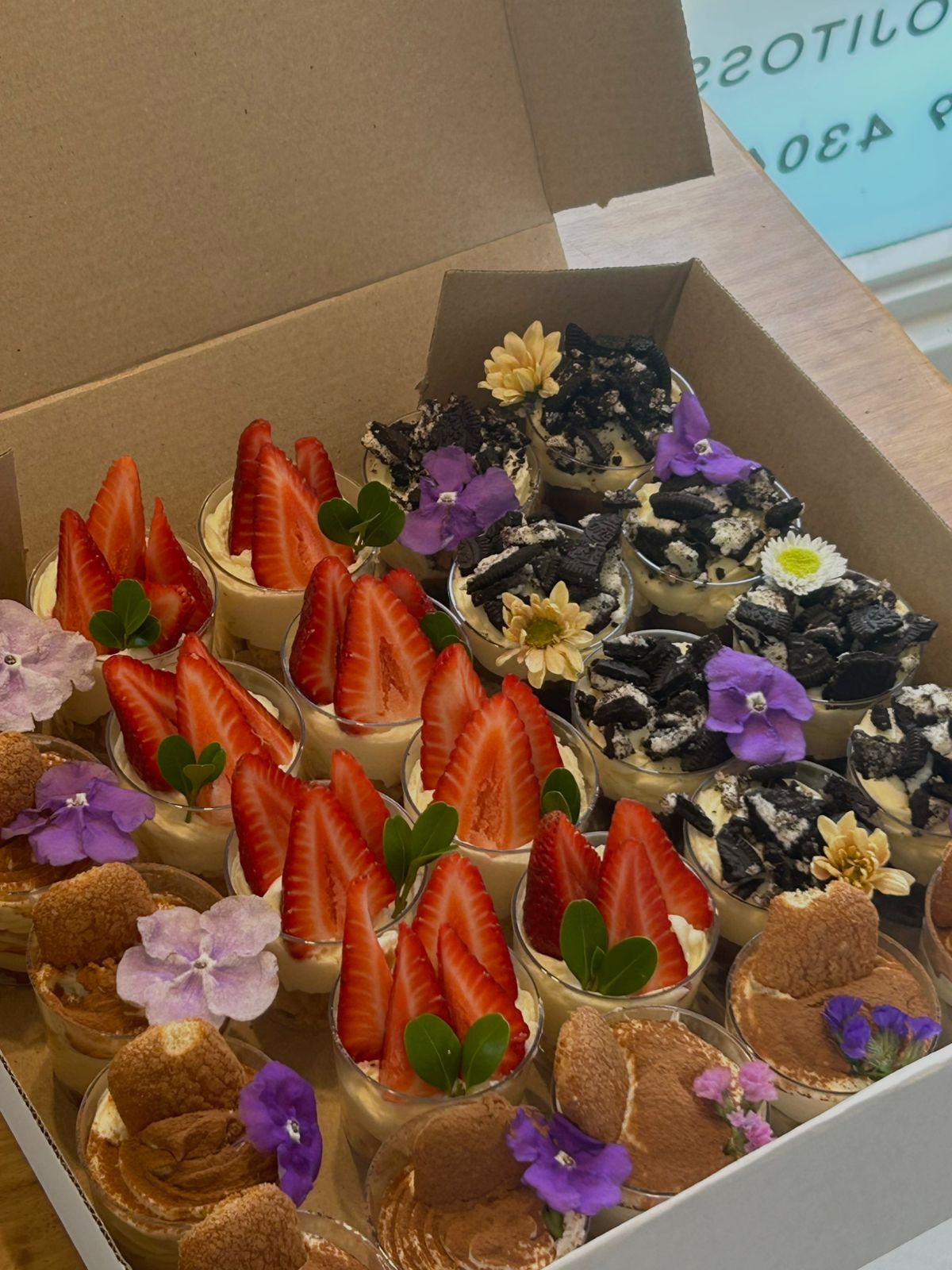Antojitos sweet table box with strawberry cups and edible flowers
