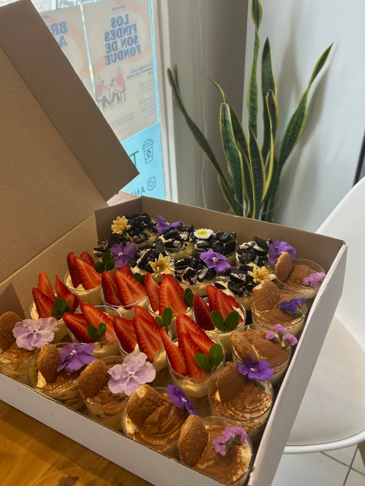 Side view of a sweet table box, with bites decorated with strawberries and flowers